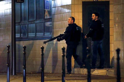 epa05023917 French police officers take cover while on the lookout for the shooters who attacked the restaurant 'Le Petit Cambodge' earlier tonight in Paris, France, 13 November 2015. At least 60 people have been killed in a series of attacks in the French capital Paris, with a hostage-taking also reported at a concert hall. EPA/ETIENNE LAURENT